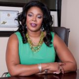 Professional headshot of Kimm Massey, Esquire, of Massey Law Group wearing a green sleeveless blouse, beaded necklaces and white looped string bracelet.